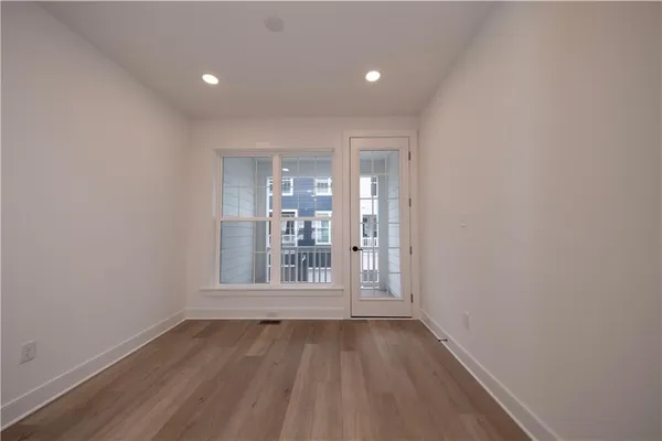 an empty room with wooden floor and windows