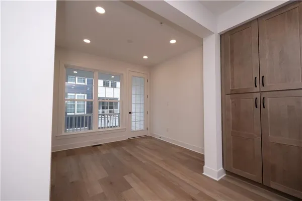 an empty room with wooden floor and windows