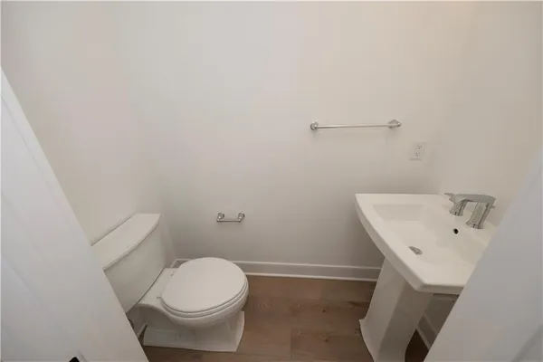a white toilet sitting next to a white sink and vanity