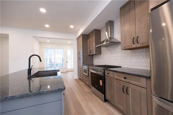 a kitchen with granite countertop a sink stainless steel appliances and cabinets