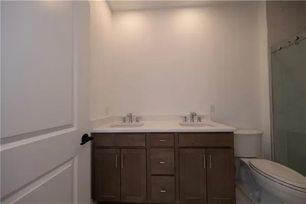 a bathroom with a shower sink vanity mirror and toilet