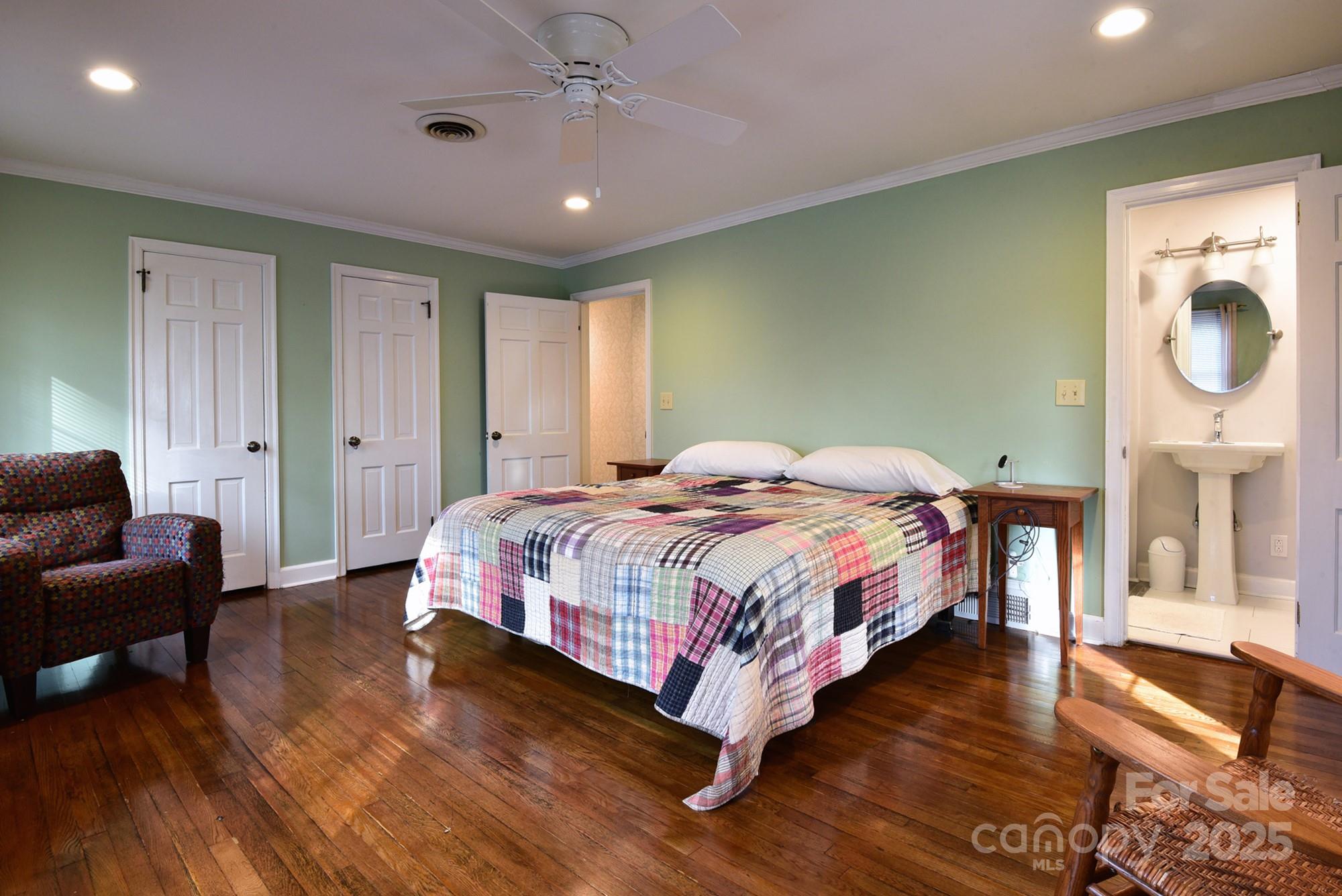 215 Biscoe Road Troy, NC 27371 - Photo 12 of 33 a bedroom with a bed a mirror on dresser and a wooden floor
