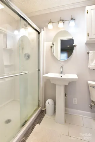 a bathroom with a sink mirror and shower