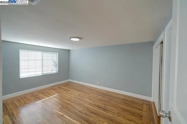 a view of a room with wooden floor and window