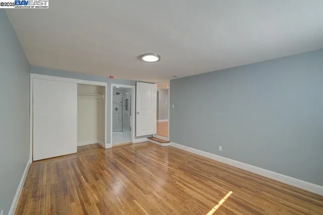 a view of empty room with wooden floor