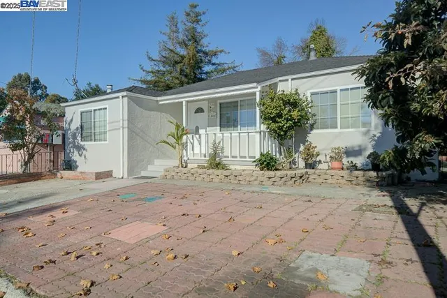 a front view of a house with a yard and potted plants