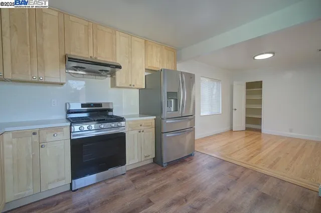 a kitchen with stainless steel appliances granite countertop a refrigerator stove and sink