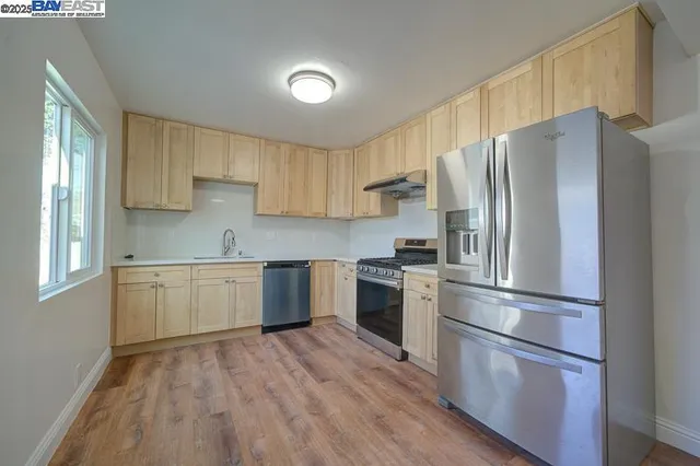 a kitchen with a refrigerator cabinets and wooden floor
