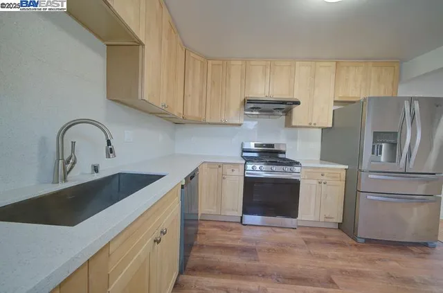 a kitchen with stainless steel appliances granite countertop a sink stove and refrigerator