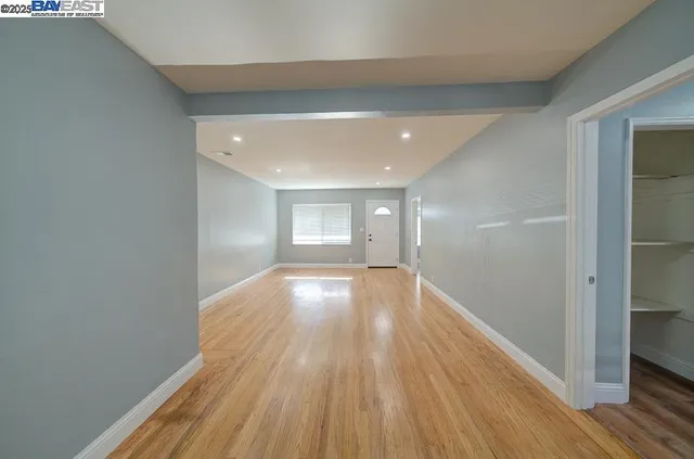 a view of empty room with wooden floor
