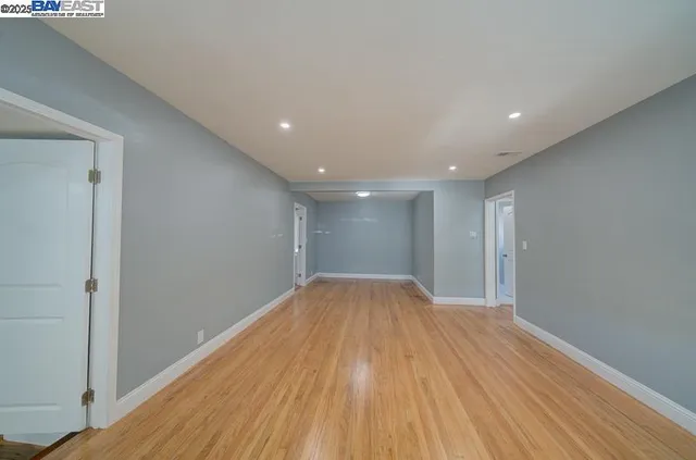 a view of empty room with wooden floor