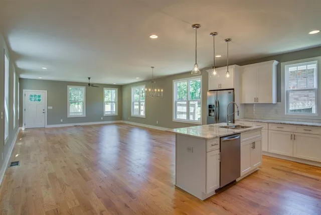 a kitchen with stainless steel appliances granite countertop a stove and a wooden floors