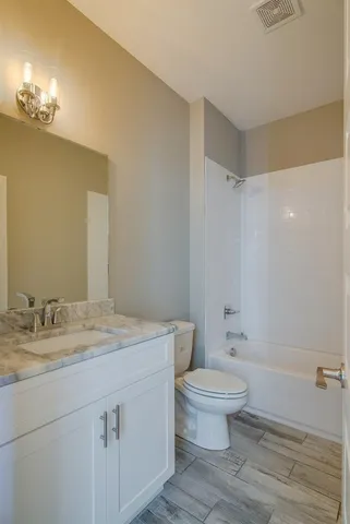 a bathroom with a granite countertop sink a toilet and a mirror