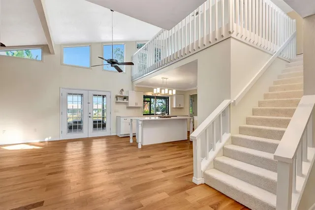 a large kitchen with kitchen island white cabinets and stainless steel appliances