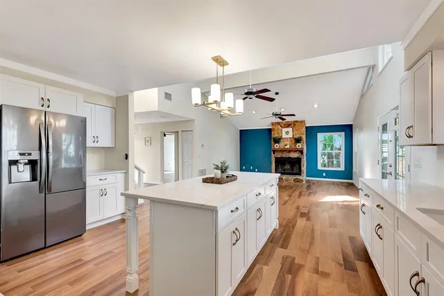 a view of an entryway with wooden floor and a kitchen view