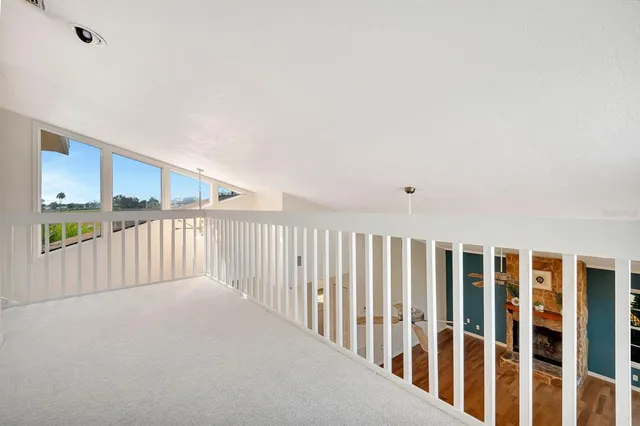 a view of a big room with wooden floor and windows