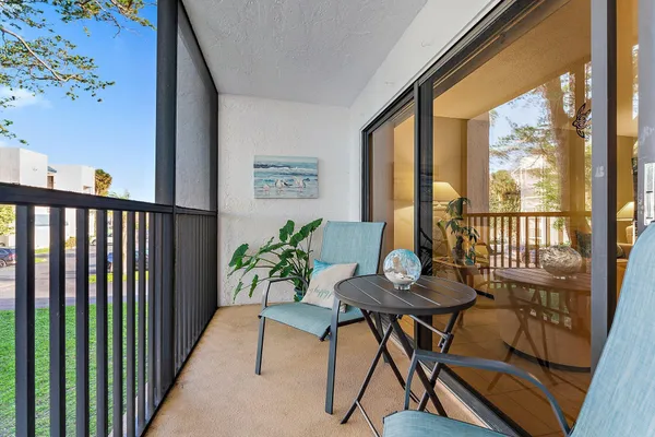 a balcony with chairs and wooden floor