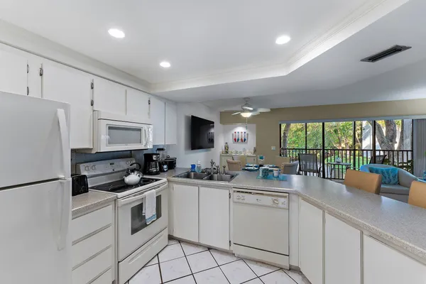 a kitchen with white cabinets and white appliances
