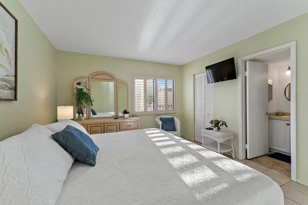 a bedroom with a bed a mirror and a large window