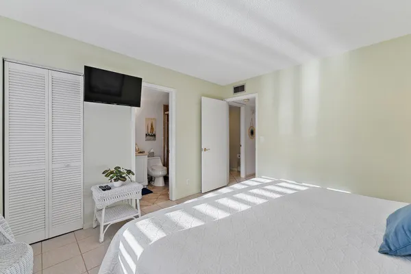 a bedroom with a large bed and a potted plant