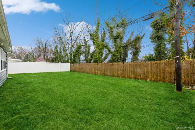 a view of yard with grass and a fence