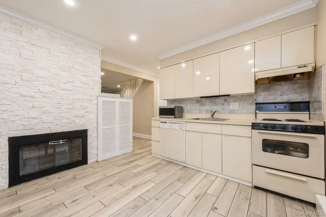 a kitchen with granite countertop white cabinets stainless steel appliances and sink
