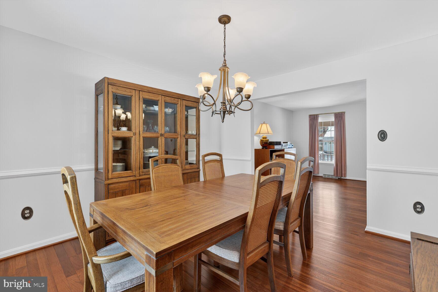 8836 Shadowlake Way Springfield, VA 22153 - Photo 31 of 77 a dining room with furniture a chandelier and wooden floor