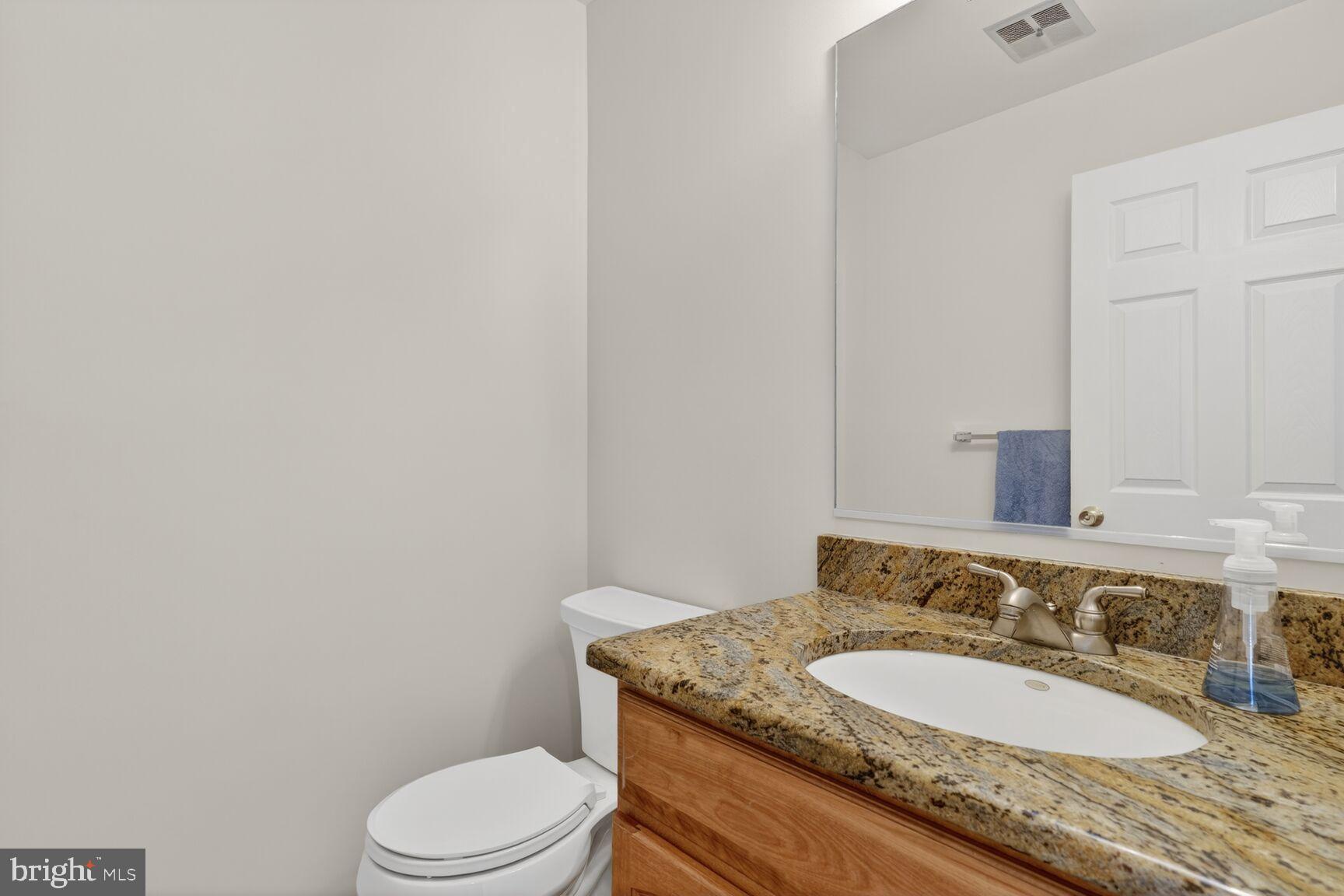 8836 Shadowlake Way Springfield, VA 22153 - Photo 34 of 77 a bathroom with a granite countertop toilet a mirror and a sink