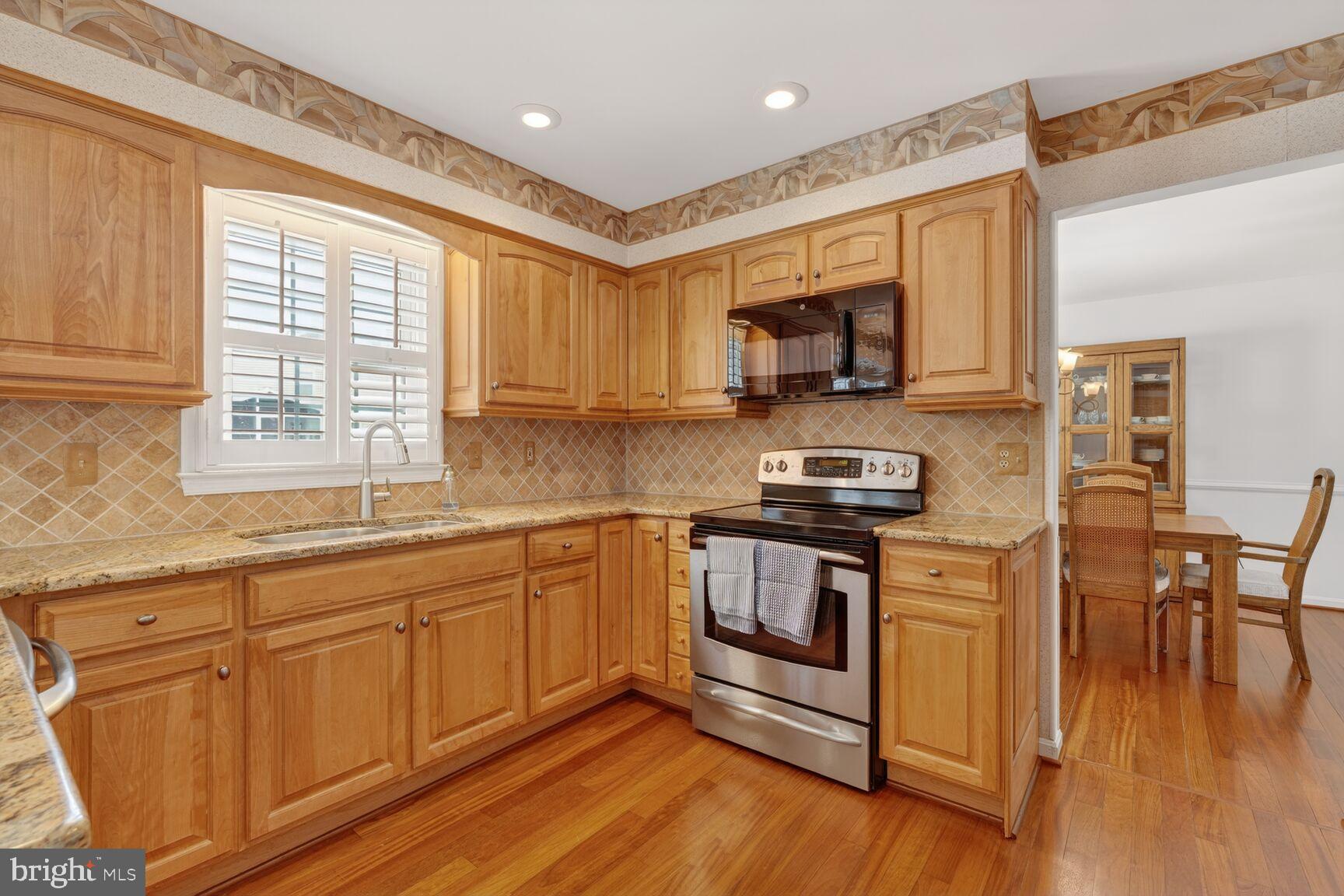 8836 Shadowlake Way Springfield, VA 22153 - Photo 6 of 77 a kitchen with stainless steel appliances granite countertop a stove a sink and a microwave