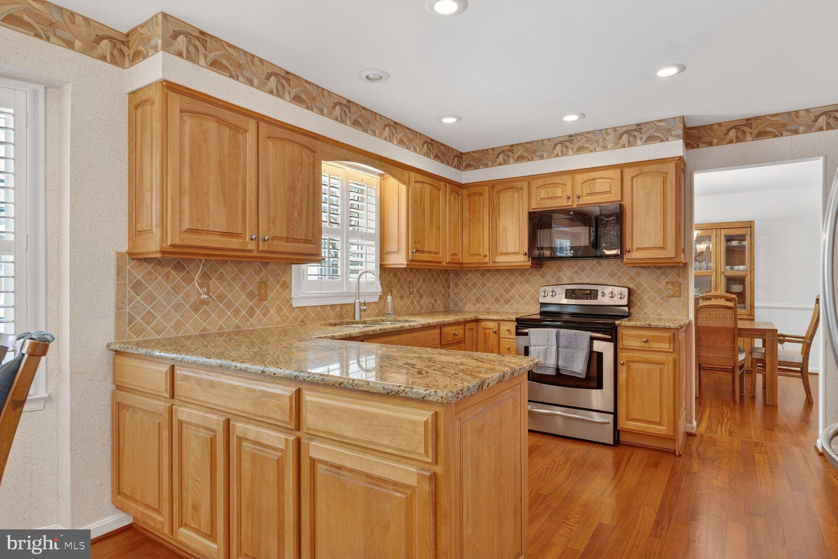 8836 Shadowlake Way Springfield, VA 22153 - Photo 8 of 77 a kitchen with stainless steel appliances granite countertop a stove a sink a microwave and a refrigerator
