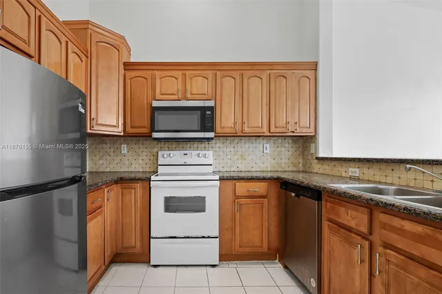 a kitchen with stainless steel appliances granite countertop a sink stove and microwave