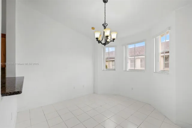 a view of a livingroom with a chandelier fan and windows