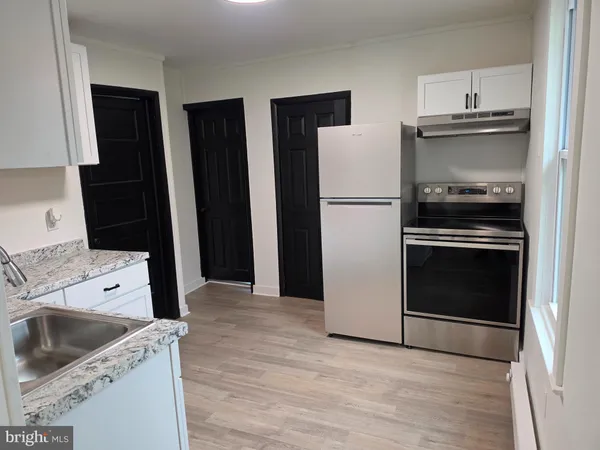 a kitchen with a refrigerator sink and cabinets
