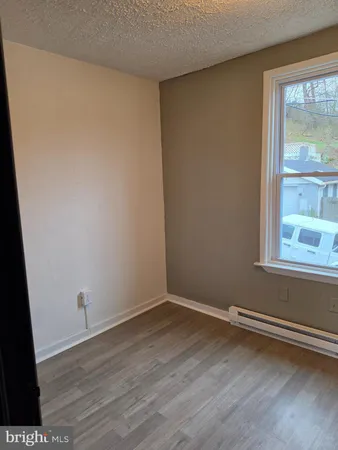 a view of a small space with wooden floor and a window