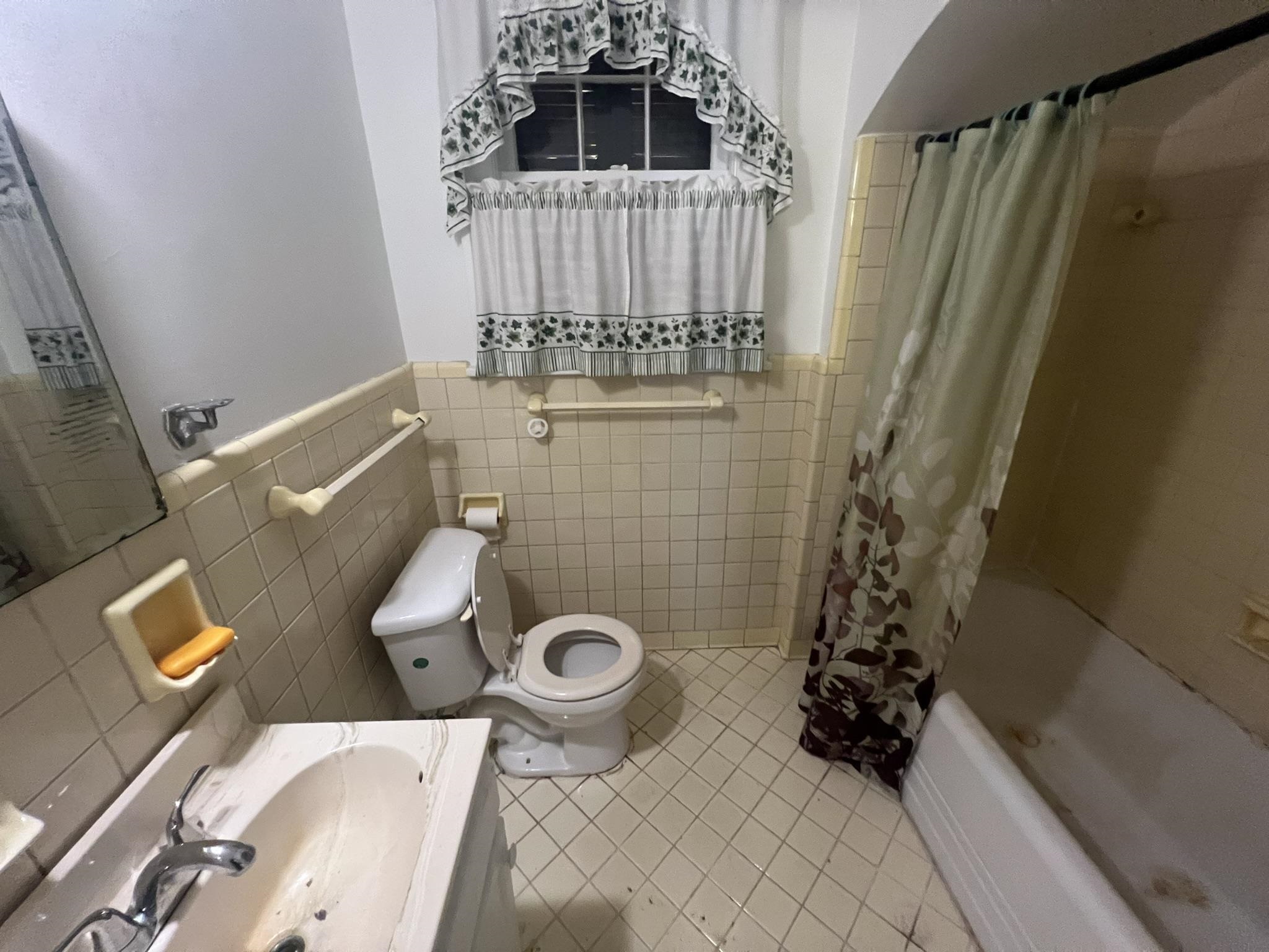 632 Spring Street Memphis, TN 38112 - Photo 16 of 37 Full bathroom with vanity, shower / bath combo, tile patterned floors, tile walls, and toilet