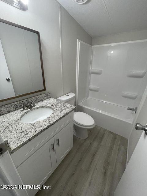 67089 Elnora Lane Yulee, FL 32097 - Photo 15 of 19 a bathroom with a granite countertop sink a toilet and a large mirror
