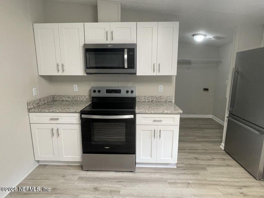 67089 Elnora Lane Yulee, FL 32097 - Photo 7 of 19 a kitchen with granite countertop white cabinets and stainless steel appliances