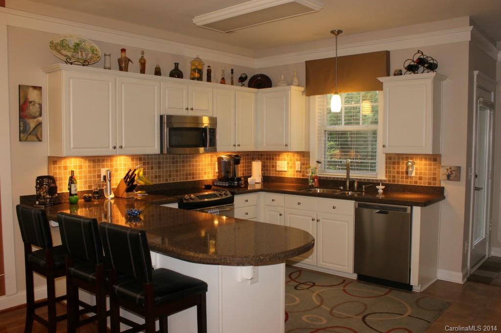 8135 Townley Road Huntersville, NC 28078 - Photo 3 of 21 a kitchen with granite countertop a sink stove and cabinets