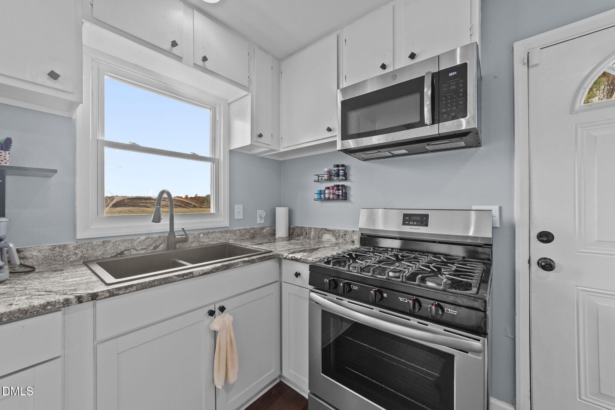 2874 Beulahtown Road Kenly, NC 27542 - Photo 9 of 40 a kitchen with stainless steel appliances granite countertop white cabinets a sink dishwasher and a stove with wooden floor