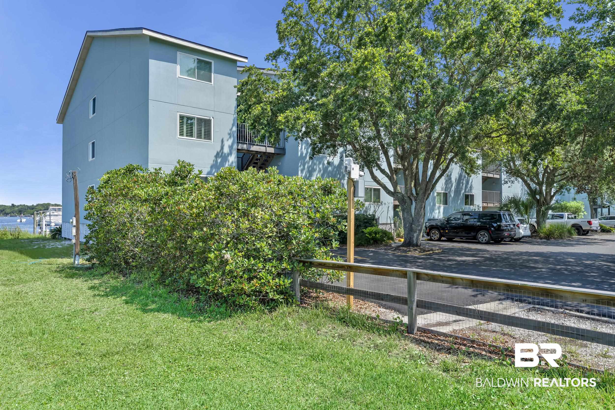 14100 River Road, Unit 211 Pensacola, FL 32507 - Photo 45 of 56 Multi-level residential building featuring light blue siding and a dark roof