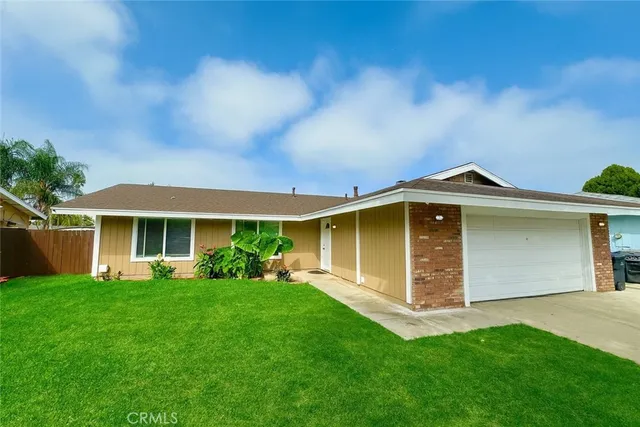 a front view of a house with a yard and trees