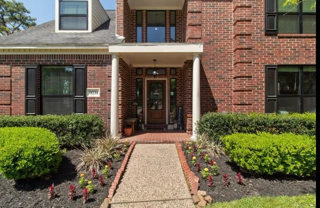 front view of a brick house with potted plants