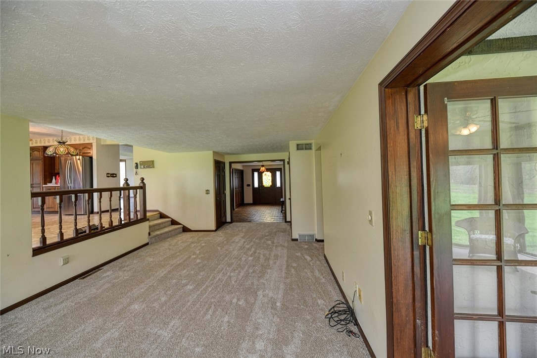 915 Sandy Lake Road Kent, OH 44240 - Photo 14 of 35 To the right of the photo, you can see a reflection of the sunroom. Ahead is the foyer and to the left up a few steps is the kitchen.