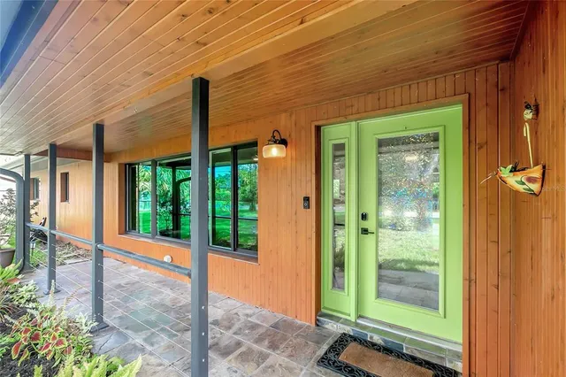 a living room with furniture a flat screen tv and a large window
