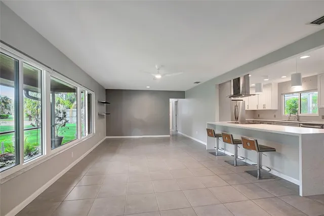 a kitchen with a dining table chairs and refrigerator