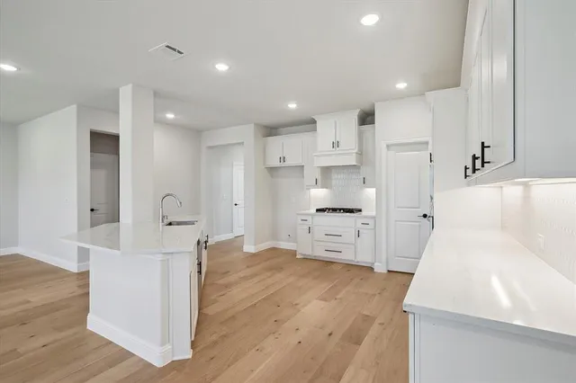 a kitchen with white cabinets and stainless steel appliances