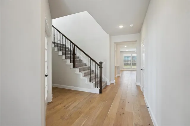 a view of a hallway with wooden floor and staircase