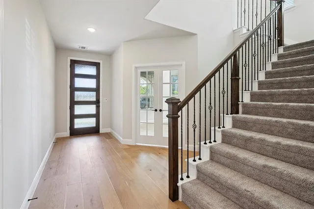 a view of staircase with wooden floor and fan