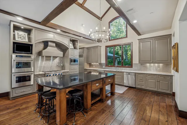 a kitchen with stainless steel appliances granite countertop a stove and cabinets