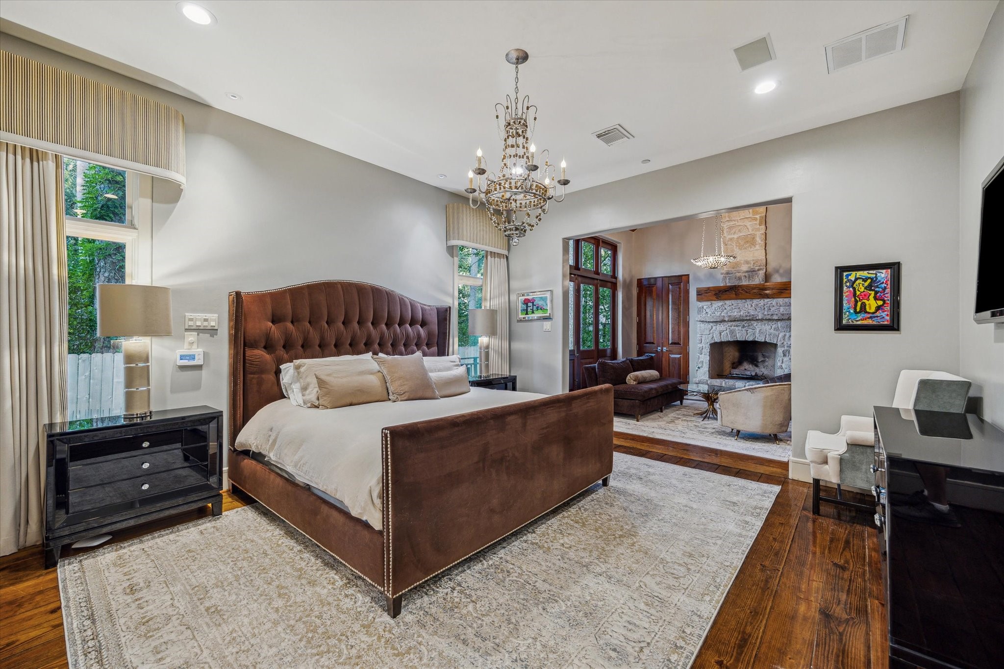 354 Piney Point Road Houston, TX 77024 - Photo 29 of 50 The spacious primary bedroom features recessed lighting and rich hardwood flooring, creating a warm and inviting atmosphere. This view is overlooking the seating space.